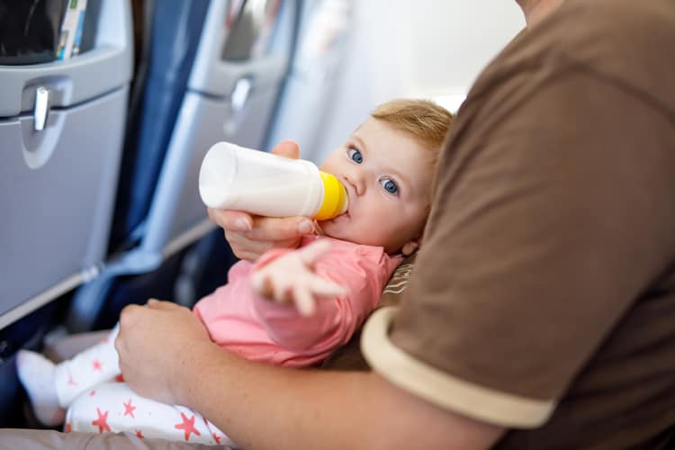 Baby Drinking Bottle On Airplane During Stress-Free Flying With Babies And Toddlers