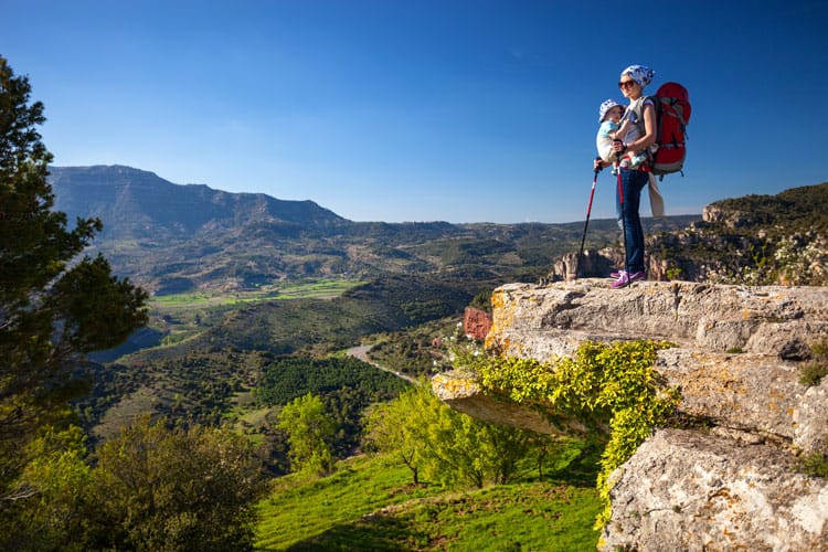woman backpacking with a child in a carrier