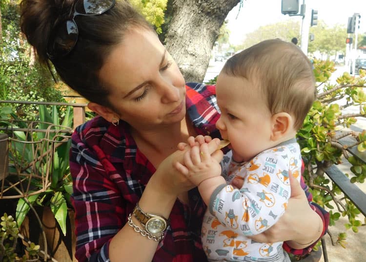 mom helping baby with travel snacks