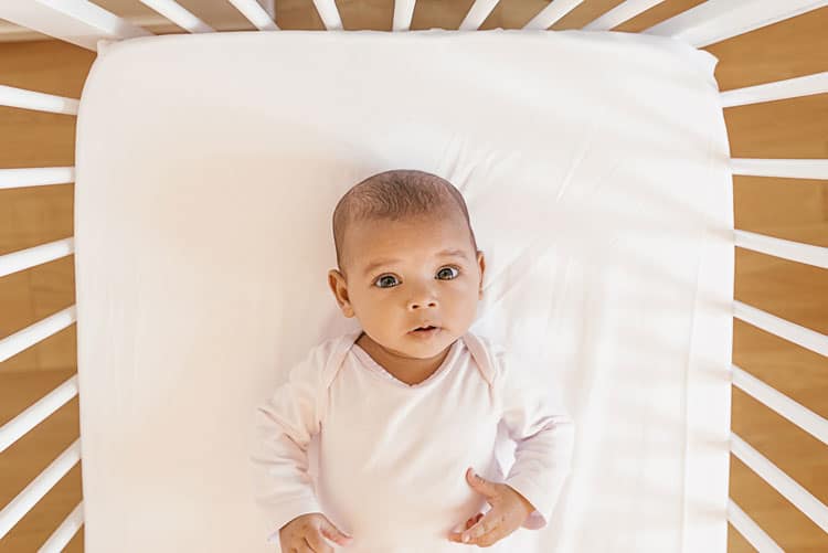 Baby Laying Awake In A Crib Trying To Adapt To A Sleep Schedule