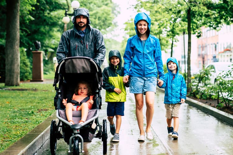 Family Walking In The Rain With A Stroller To Disney World