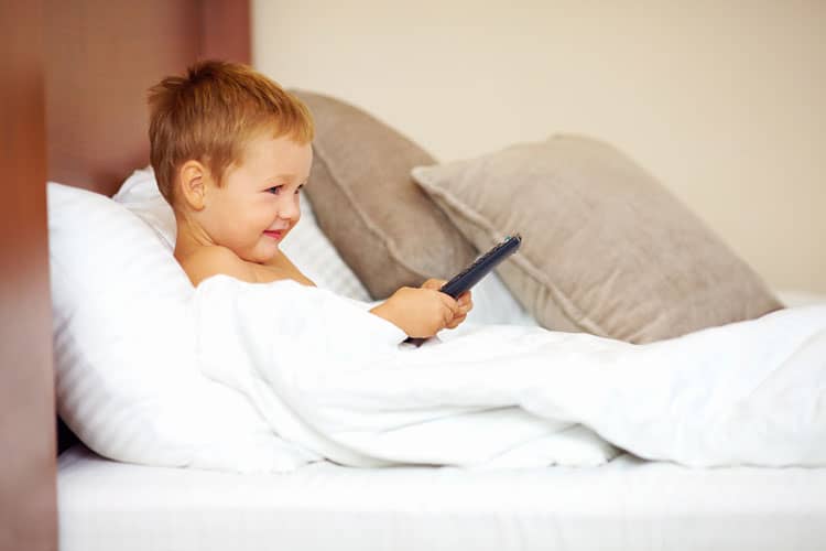Child Relaxing In Hotel Room Bed