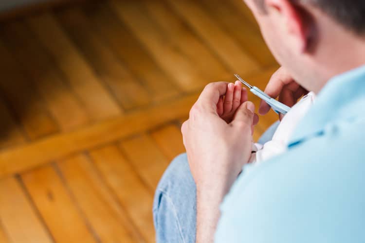father clipping baby's nails