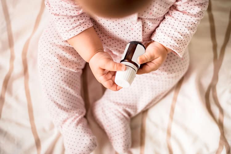 child holding a bottle of essential oils