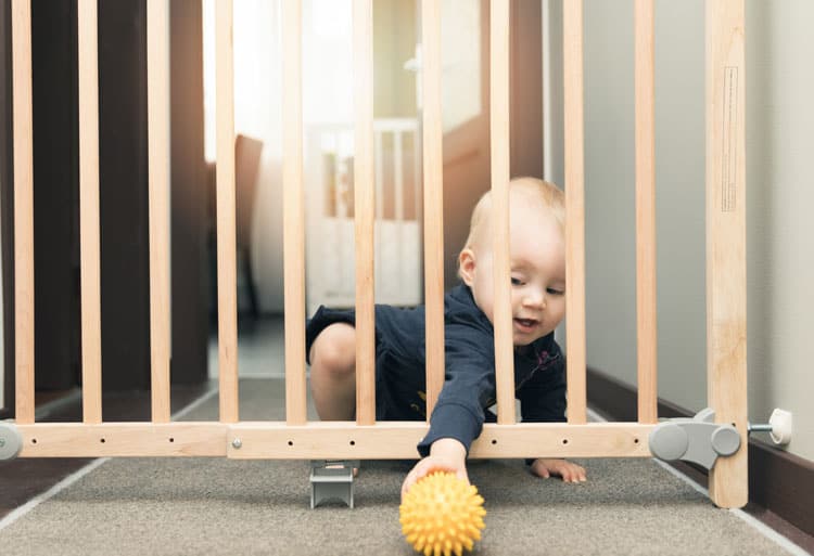 baby playing near baby gate