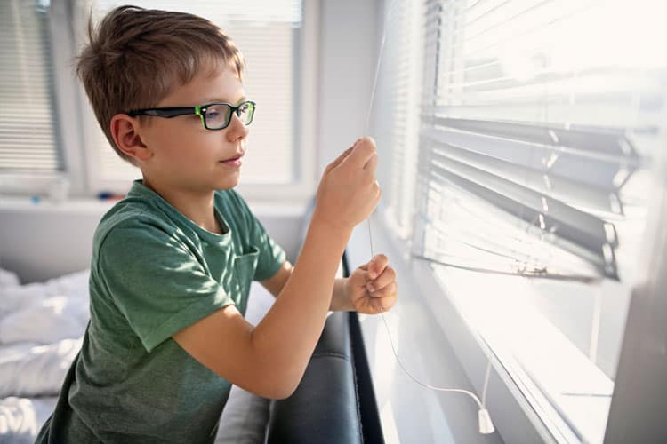 boy opening the blinds