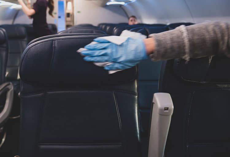 Hand Wiping Down Airplane Seat With Sanitizing Wipes