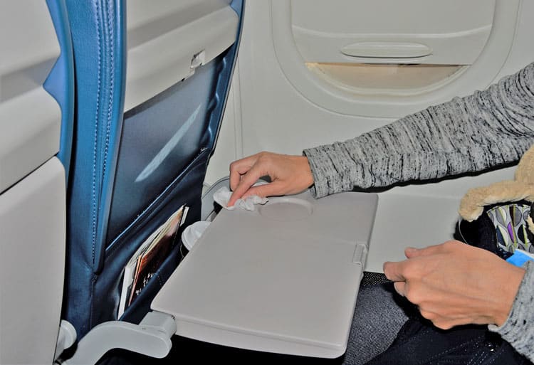 Someone Wiping Down Airplane Tray Table