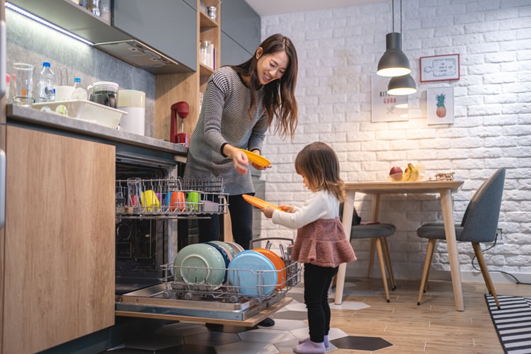 Mom Showing Daughter How To Load Dishwasher