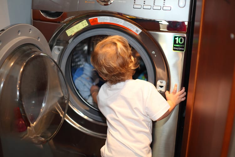 Child Reaching Into The Washing Machine