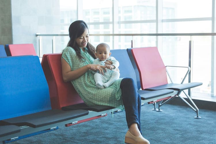 Mother Sitting In Airport With Infant