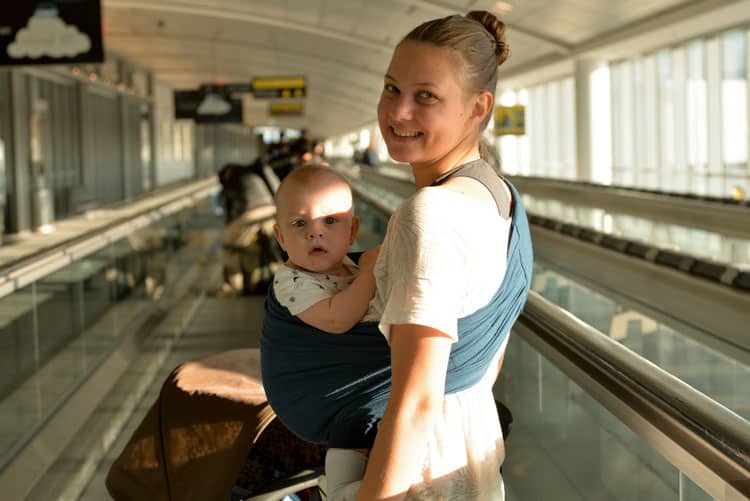 Woman In Airport With Baby In A Carrier