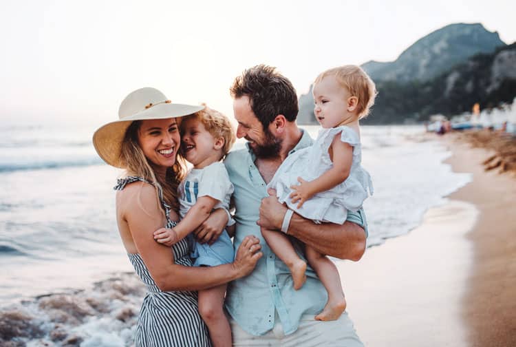 {Updated} Family Travel On A Budget: 17 Tips To Help You Save Money 4 Travel Is Back - Happy Family On The Beach